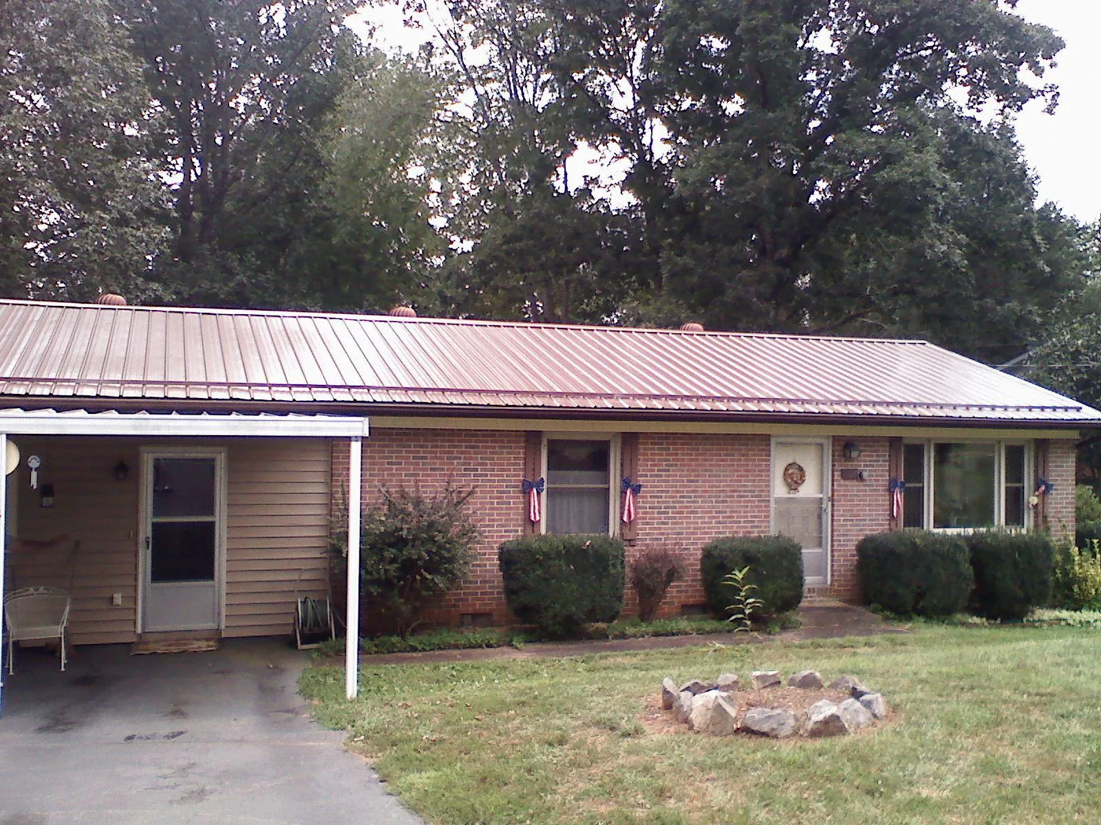 Bronze metal roof and carport on a brick ranch home — Roof Repair work by our crew in Clarks Mills